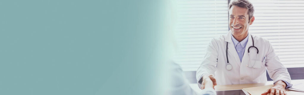 do lado esquerdo um fundo cinza claro e do lado direito Foto de um médico branco sentado sorrindo apertando a mão de um paciente no consultório.